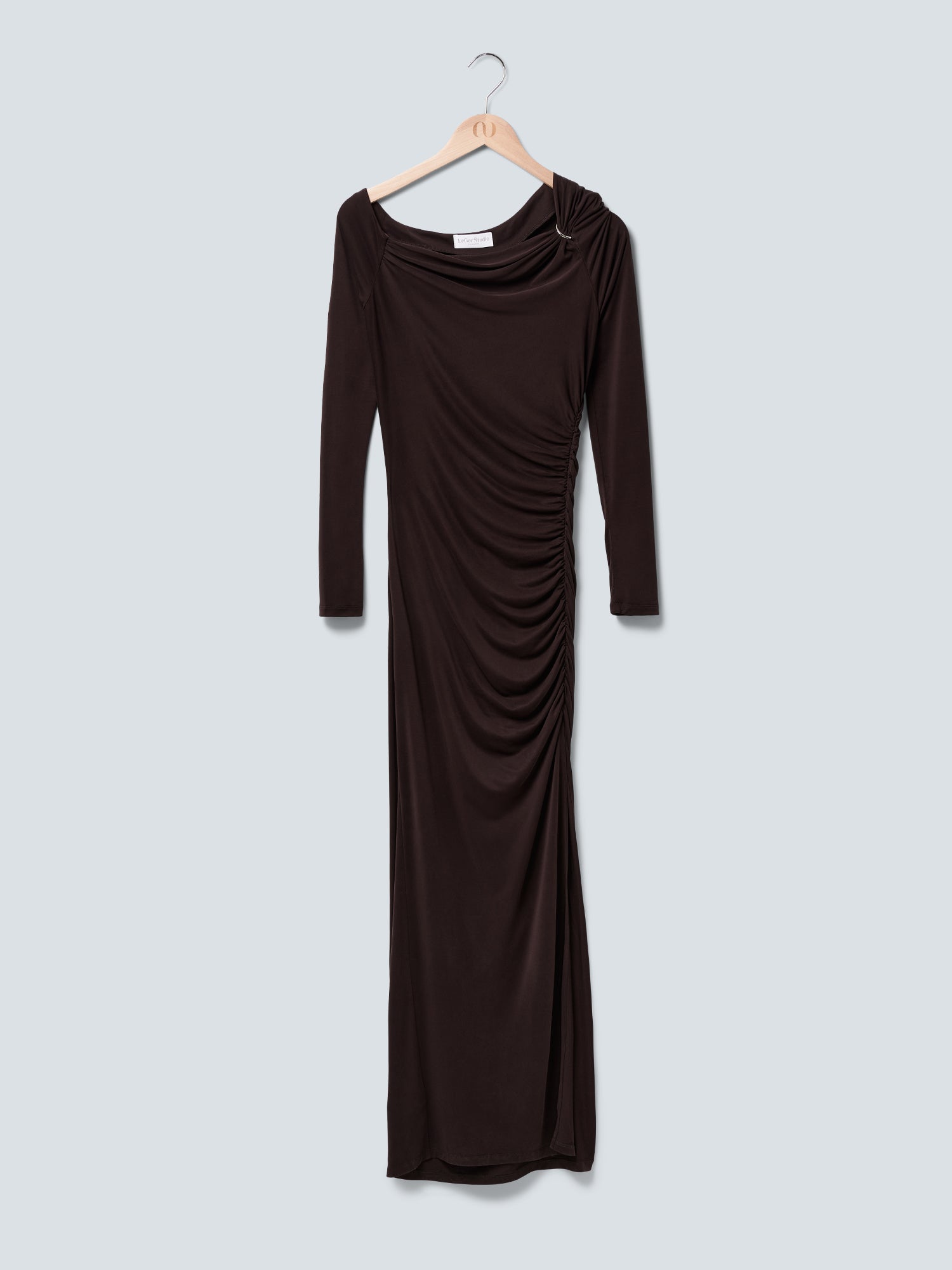 Ein braunes, langärmeliges „Adline“-Kleid von LeGer by Lena Gercke mit geraffter, figurbetonter Passform, drapiertem Ausschnitt und einem silbernen Ringdetail an der Schulter ist auf einem Holzkleiderbügel aufgehängt.