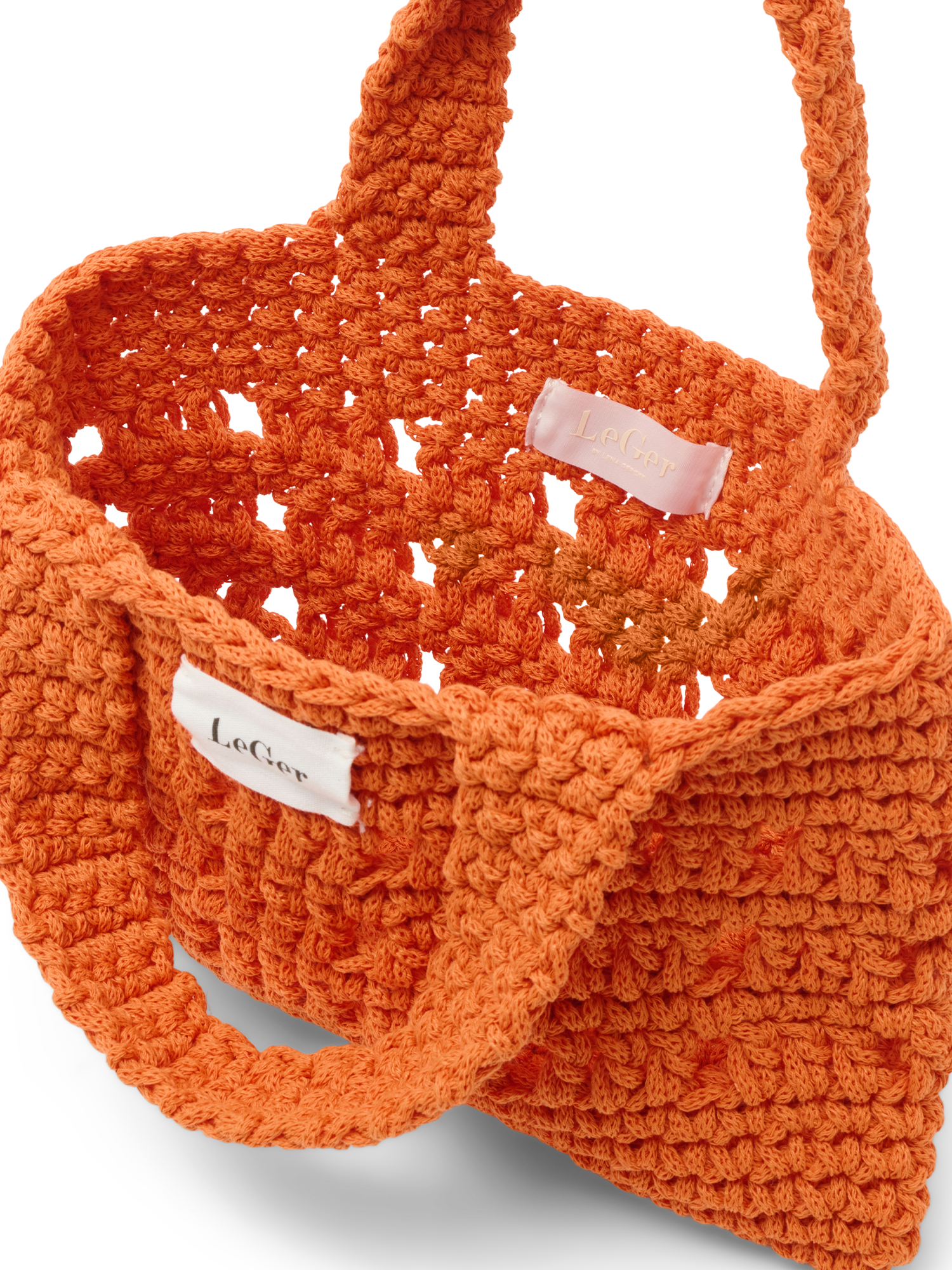 Nahaufnahme der orangefarbenen „Valerie“-Tasche von LeGer by Lena Gercke, die die detailreiche Häkelstruktur und ein weißes LeGer-Markenetikett hervorhebt.