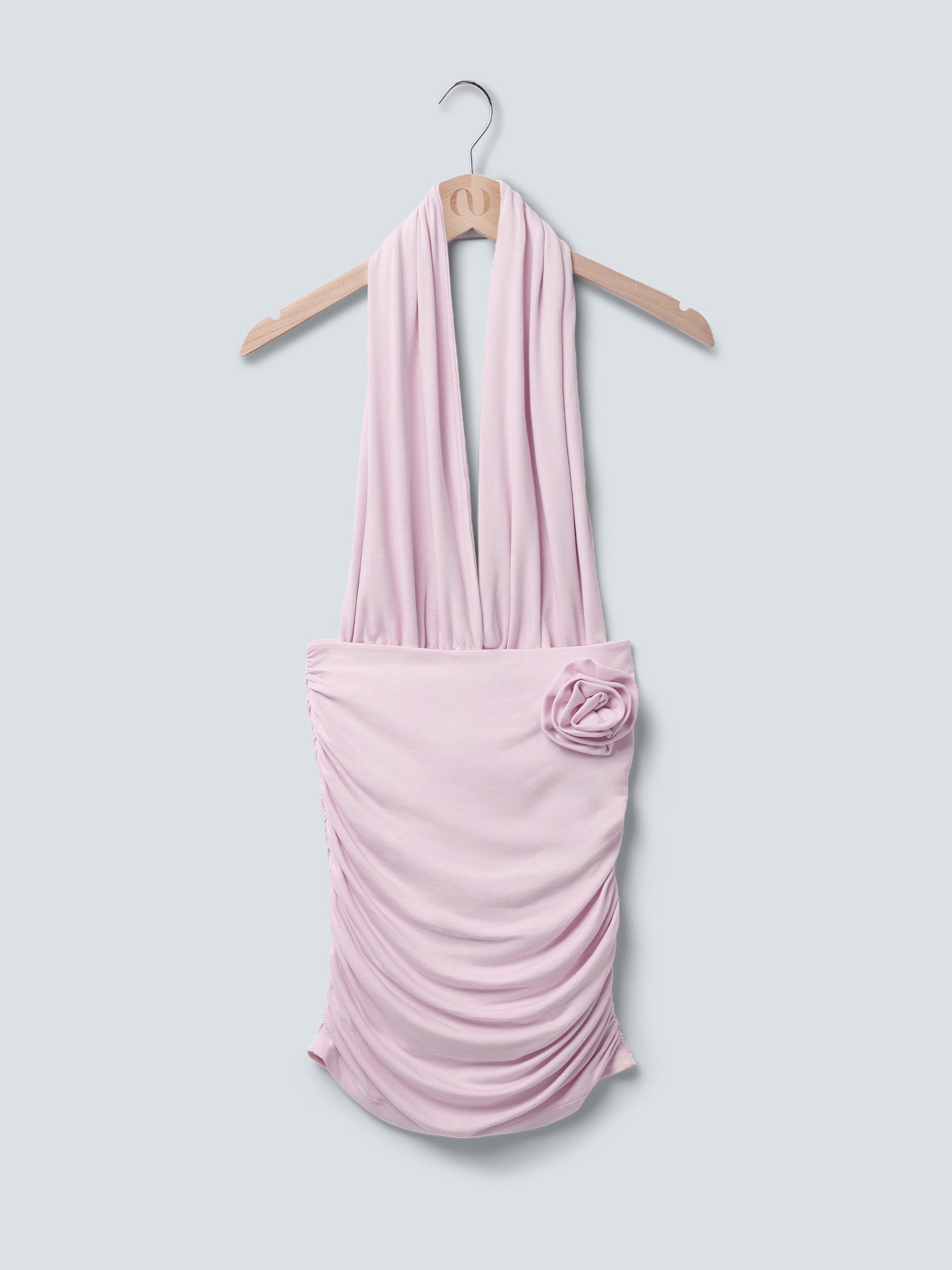 Das „Rosie“-Kleid von LeGer by Lena Gercke ist ein hellrosa, drapiertes Neckholder-Damenkleid mit gerafftem Rock und einer Stoffblume an der Hüfte, das auf einem Holzbügel vor einem schlichten hellgrauen Hintergrund präsentiert wird.