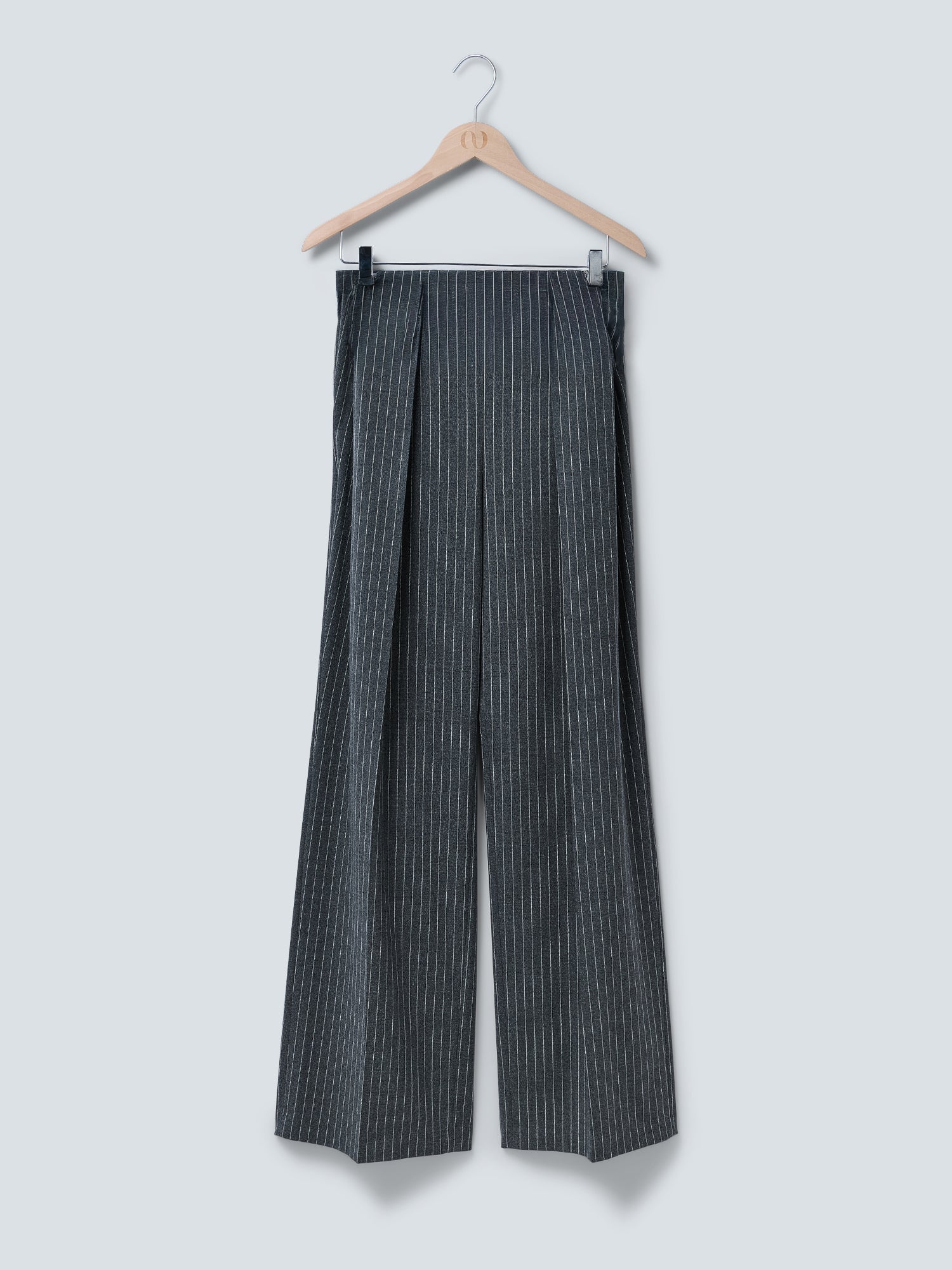 Die Hose „Sophia“ von LeGer by Lena Gercke mit grauem Nadelstreifenmuster und weitem Beinschnitt hängt auf einem Holzkleiderbügel vor einem hellgrauen Hintergrund – damit ist diese elegante Damenhose die perfekte Wahl als bequeme Businesshose.