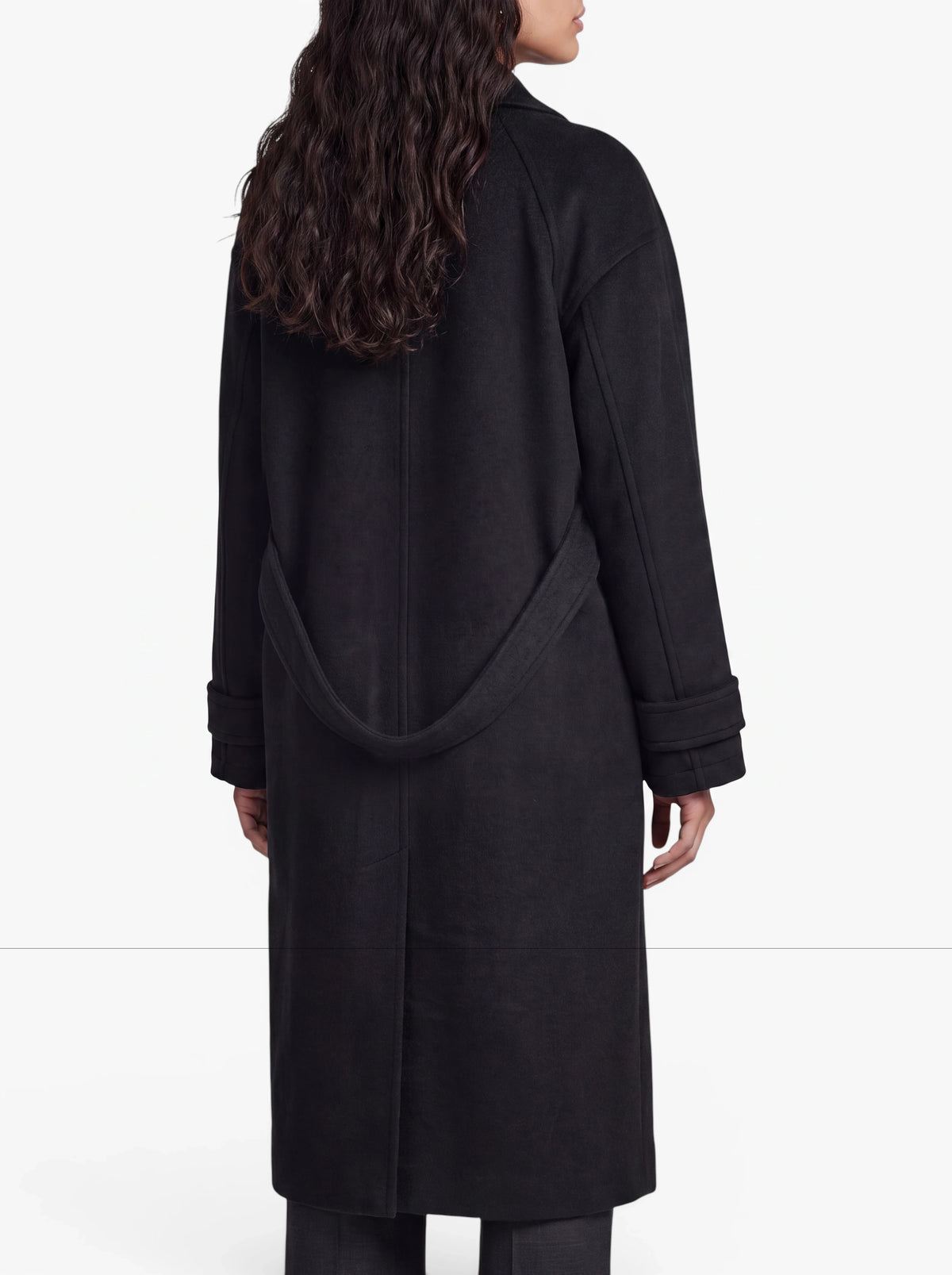 Eine Person mit langen, gewellten Haaren ist von hinten zu sehen und trägt den Mantel „Sybille“ von LeGer by Lena Gercke. Dieser schwarze Mantel verfügt über Raglanärmel, einen breiten Kragen, Ärmel mit Manschetten, ein Gürteldetail am Rücken und ist mit einer eleganten einreihigen Knopfleiste versehen. Der Hintergrund ist schlicht weiß.