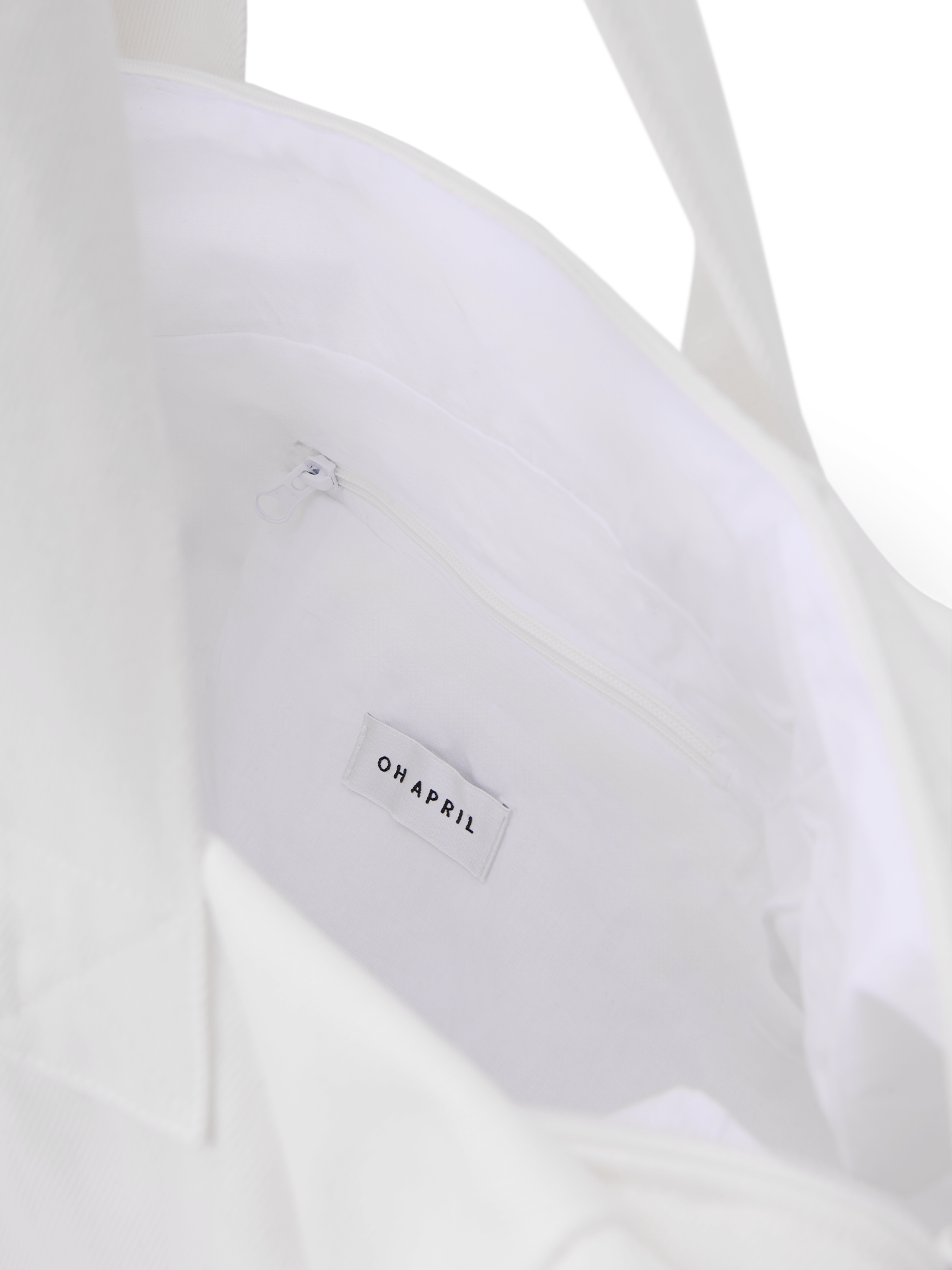 Der LeGer x Oh April - Anni Shopper von LeGer by Lena Gercke hat eine weiße Innenausstattung mit einer Reißverschlusstasche und einem "OH APRIL" Stoffetikett. Das Model (1,73 m) trägt Größe 36.