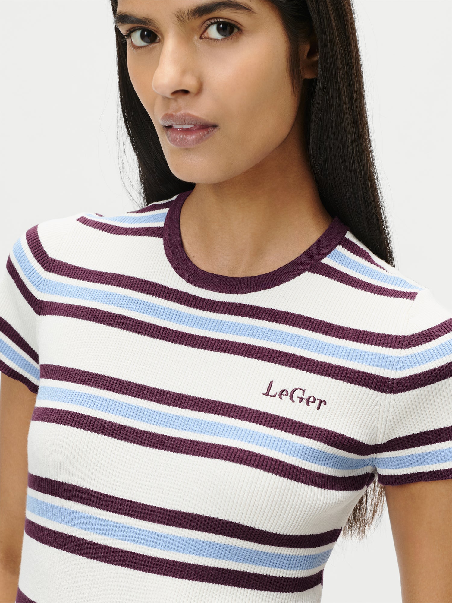 Eine Person mit langen dunklen Haaren trägt das Danielle T-Shirt von LeGer by Lena Gercke, ein schmales geripptes Kurzarm-Top mit weißen, bordeauxroten und hellblauen Querstreifen. Auf der Brust ist "LeGer" aufgestickt. Das Oberteil ist in Größe 36 abgebildet.