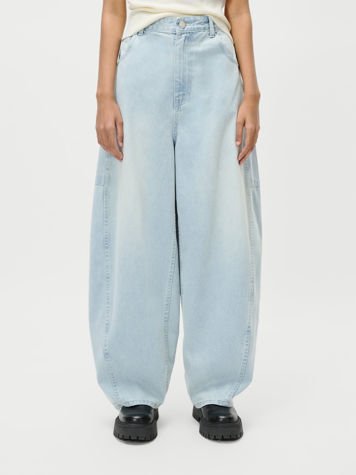 Das Model trägt die LeGer by Lena Gercke Eilika Pants in Hellblau, Größe 36, gepaart mit schwarzen, klobigen Schuhen. Nur der untere Teil des Oberkörpers und die Beine sind vor einem einfarbig weißen Hintergrund abgebildet.