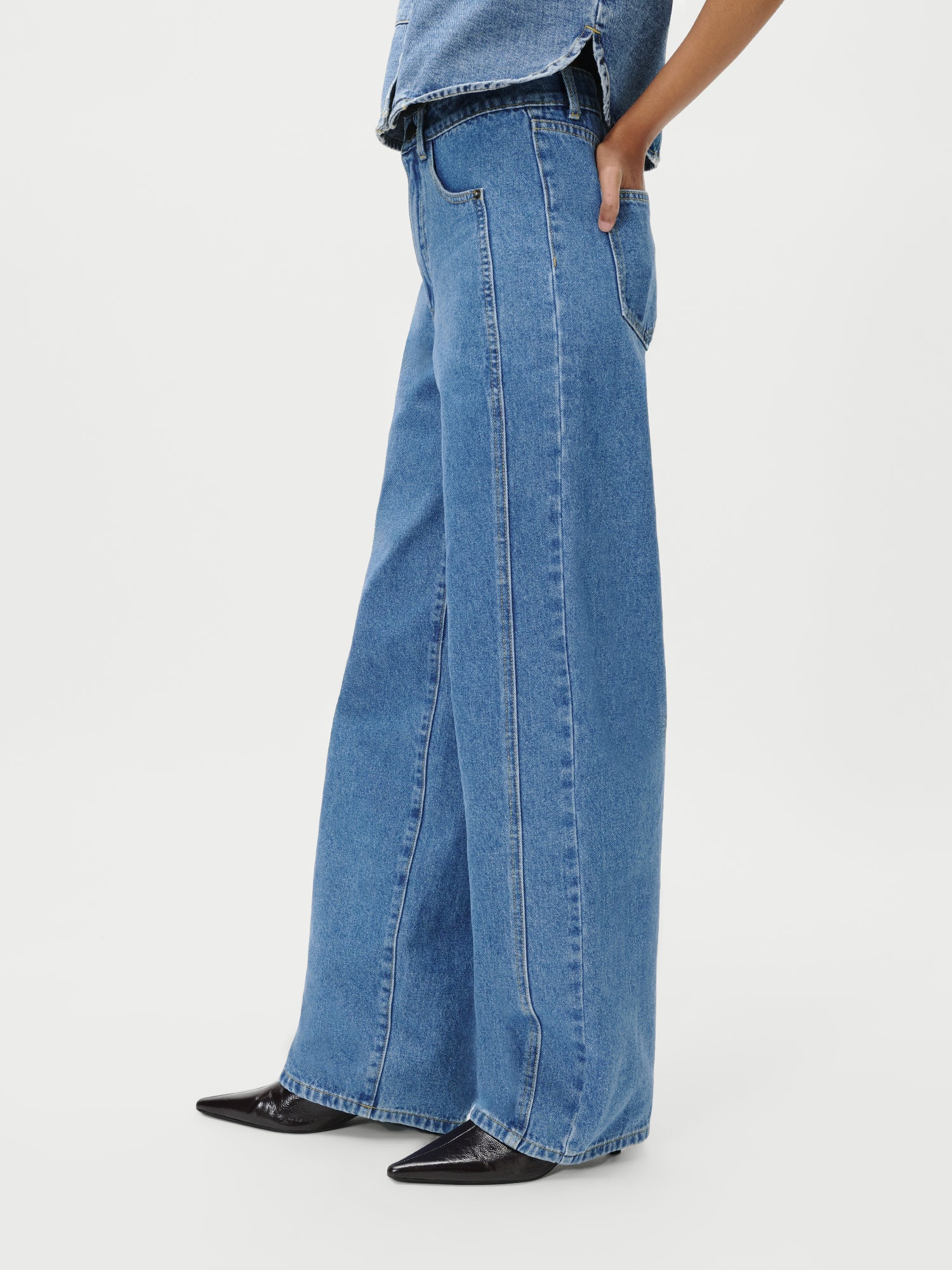 Eine Person, die Shirin Pants von LeGer by Lena Gercke in Größe 36 und schwarze spitze Schuhe trägt, steht mit einer Hand in der Tasche. Nur der Unterkörper ist vor einem schlichten weißen Hintergrund zu sehen.