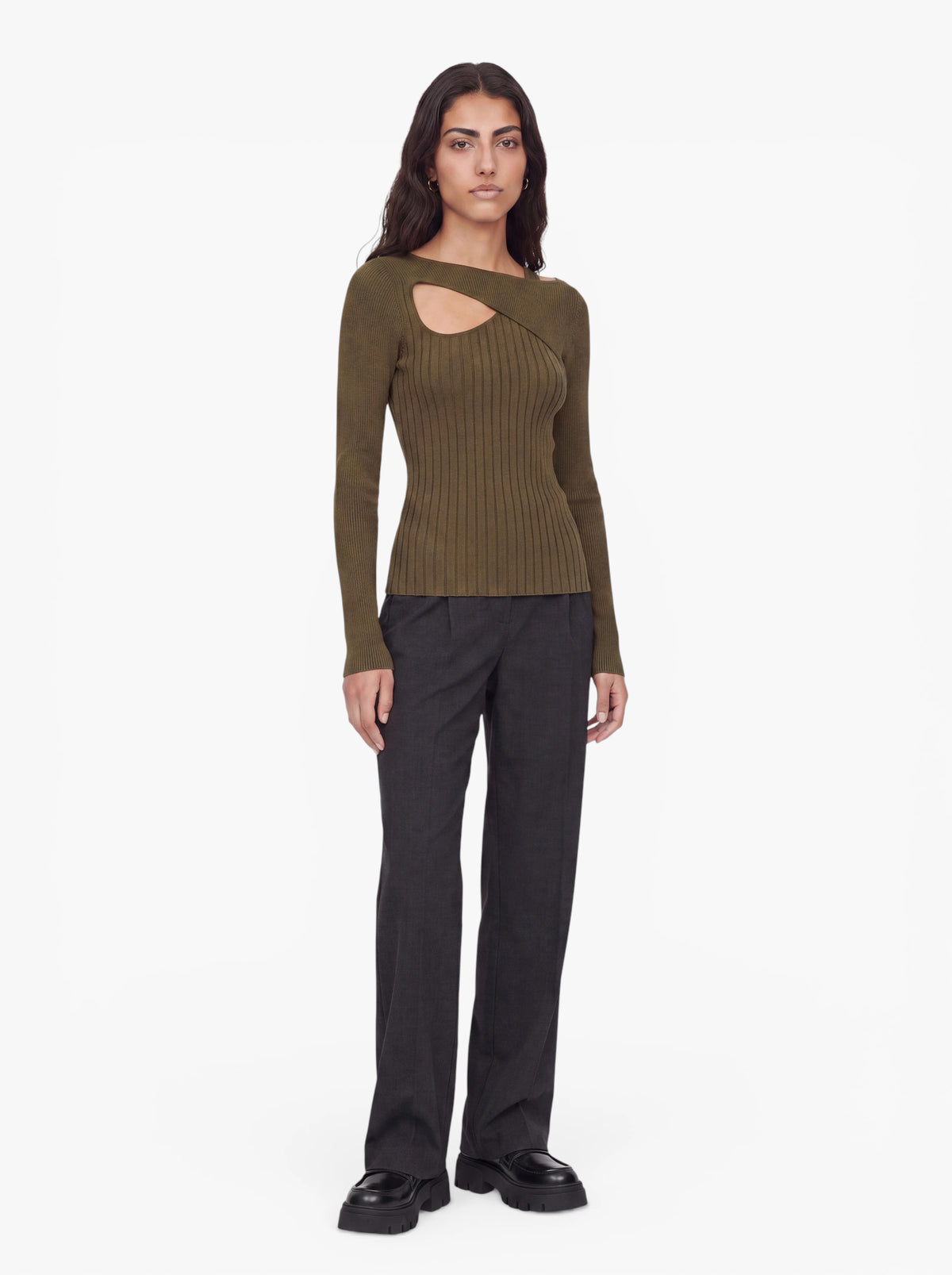 Eine Person, die den Pullover „Selina“ von LeGer by Lena Gercke trägt – einen olivgrünen, gerippten Strickpullover mit einem stilvollen Ausschnitt im Brustbereich –, steht in Kombination mit einer schwarzen Hose vor einem schlichten weißen Hintergrund.