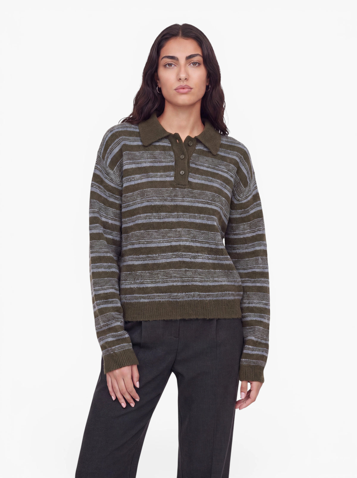 Eine Person mit langen dunklen Haaren trägt den Pullover „Delia“ von LeGer by Lena Gercke mit olivgrünen Streifen und Hemdkragen, dazu eine dunkle Hose, und steht vor einem schlichten weißen Hintergrund.